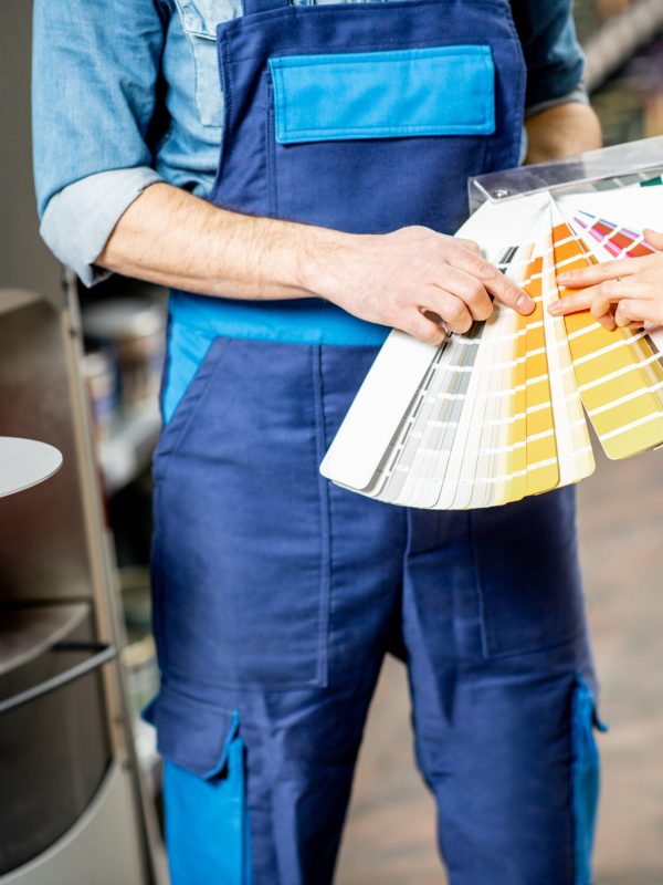 Choosing paint from color swatches in the building shop, close-up view